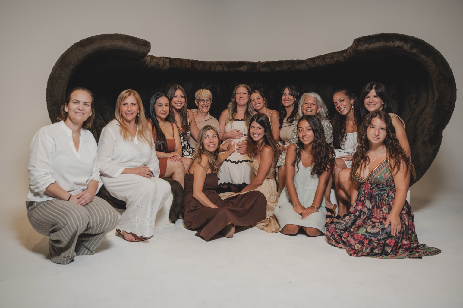A multigenerational circle of women gathered around an expectant mother
